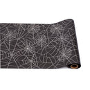 Roll of black paper with white spider web pattern on a white background