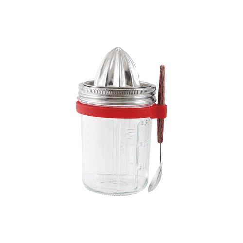 Clear glass jar with metal citrus press and red silicone spoon holder with a spoon on a white background