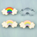 Decorative cookies with rainbow and cloud designs on a light blue background, accompanied by a metal cookie cutter shaped like a rainbow with clouds.