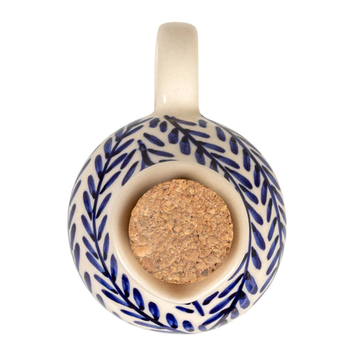 Ceramic cruet with blue leaf pattern and cork base on a white background