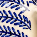 Close-up of blue leaf pattern on a ceramic cruet