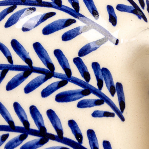 Close-up of blue leaf pattern on a ceramic cruet