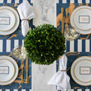 Elegant table setting with place cards and green centerpiece on a decorative tablecloth.