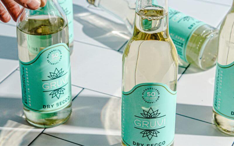 Several Gruvi Dry Secco bottles on a white surface.