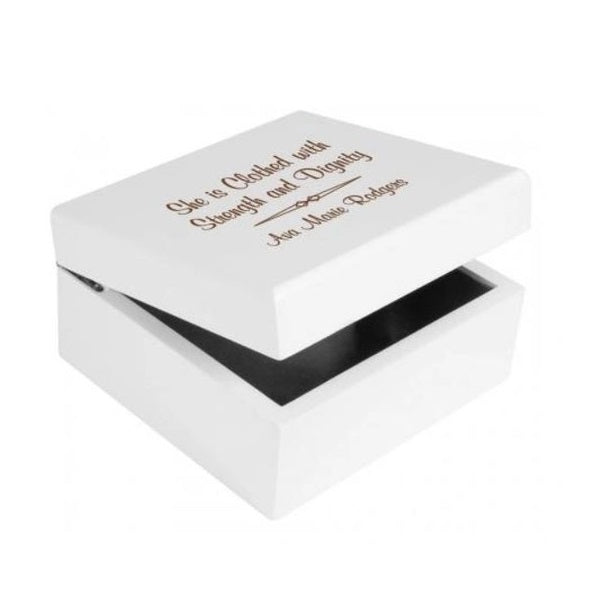A white jewelry box with a personalized engraving on the lid, featuring text and a name.