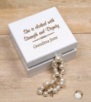 A customized white wooden jewelry box with a pearl necklace coming out of it on a wooden surface.