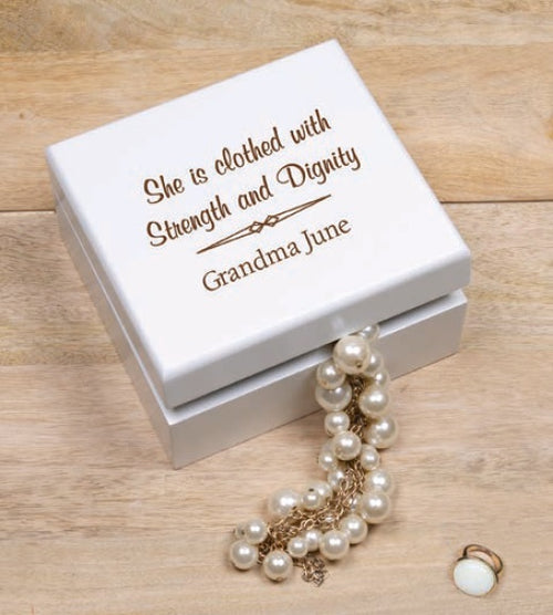 A customized white wooden jewelry box with a pearl necklace coming out of it on a wooden surface.