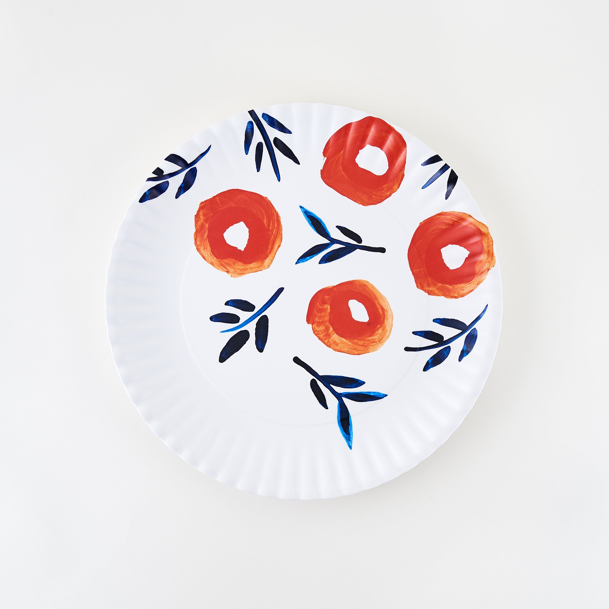 A white melamine platter with floral patterns in red and blue hues and crimped edges.