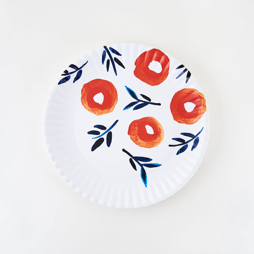 A white melamine platter with floral patterns in red and blue hues and crimped edges.