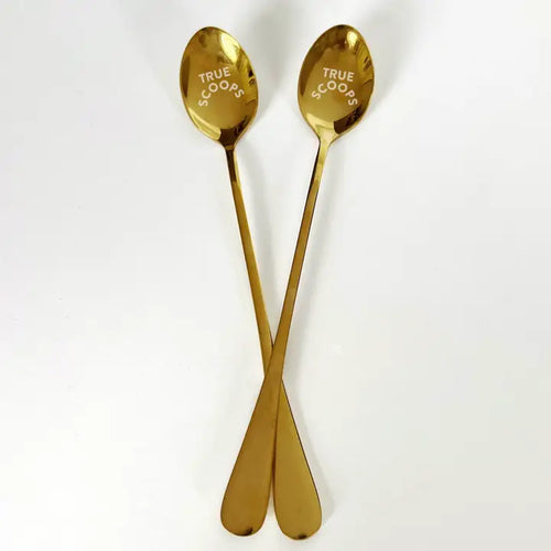 Two gold-colored ice cream spoons with the text 'True Scoops' laser engraved on the handle, displayed against a white background.