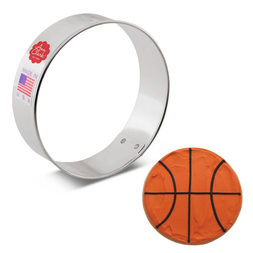 Metallic cookie cutter shaped like a circle with an example cookie made to look like a basketball on a white background