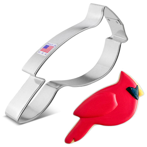 A stainless steel cookie cutter in the shape of a red cardinal bird with an example cardinal cookie.