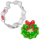 Christmas wreath cookie cutter with a decorated cookie on a white background