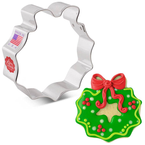 Christmas wreath cookie cutter with a decorated cookie on a white background