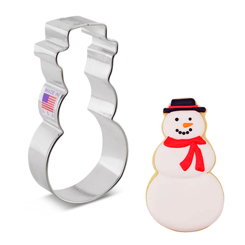 A cookie cutter in the shape of a snowman with a hat alongside a finished cookie as an example on a white background.
