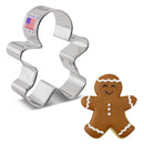 A cookie cutter shaped like a gingerbread man with a sticker that says 'made in USA' next to a gingerbread man cookie.