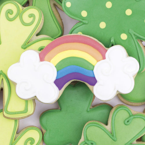Decorative shamrock cookies with a rainbow cookie on top.
