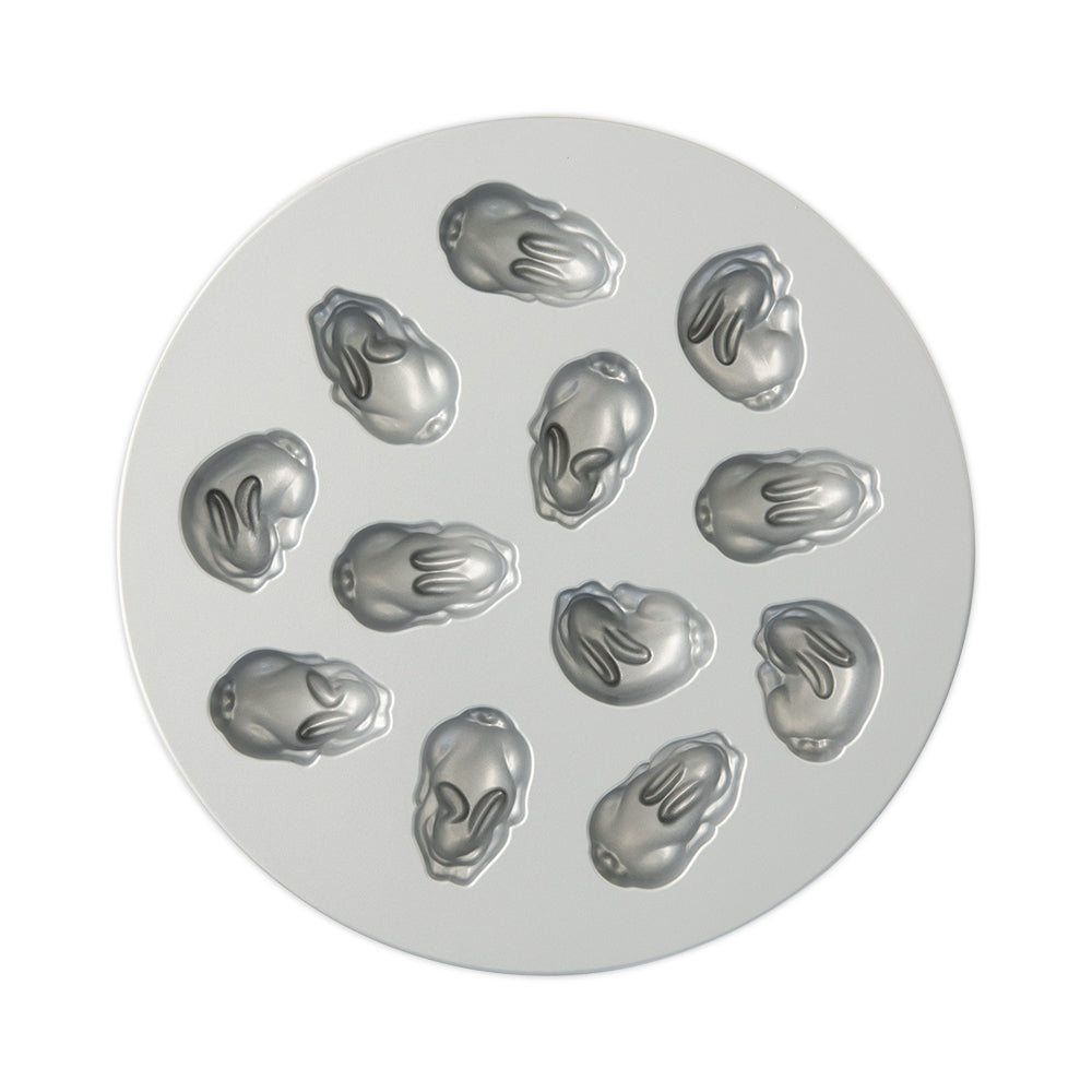 Circular metal mold with multiple baby bunny-shaped cavities on a white background