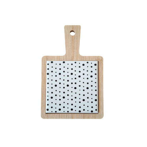 Wooden mini serving board with black and white dots on a white background.