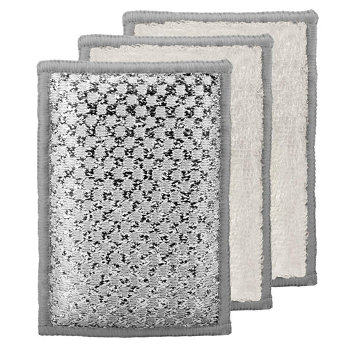 Three rectangular Oggi sponges stacked slightly offset, showing a silver-gray patterned front and soft off-white textured backs with gray edges, on a plain white background.