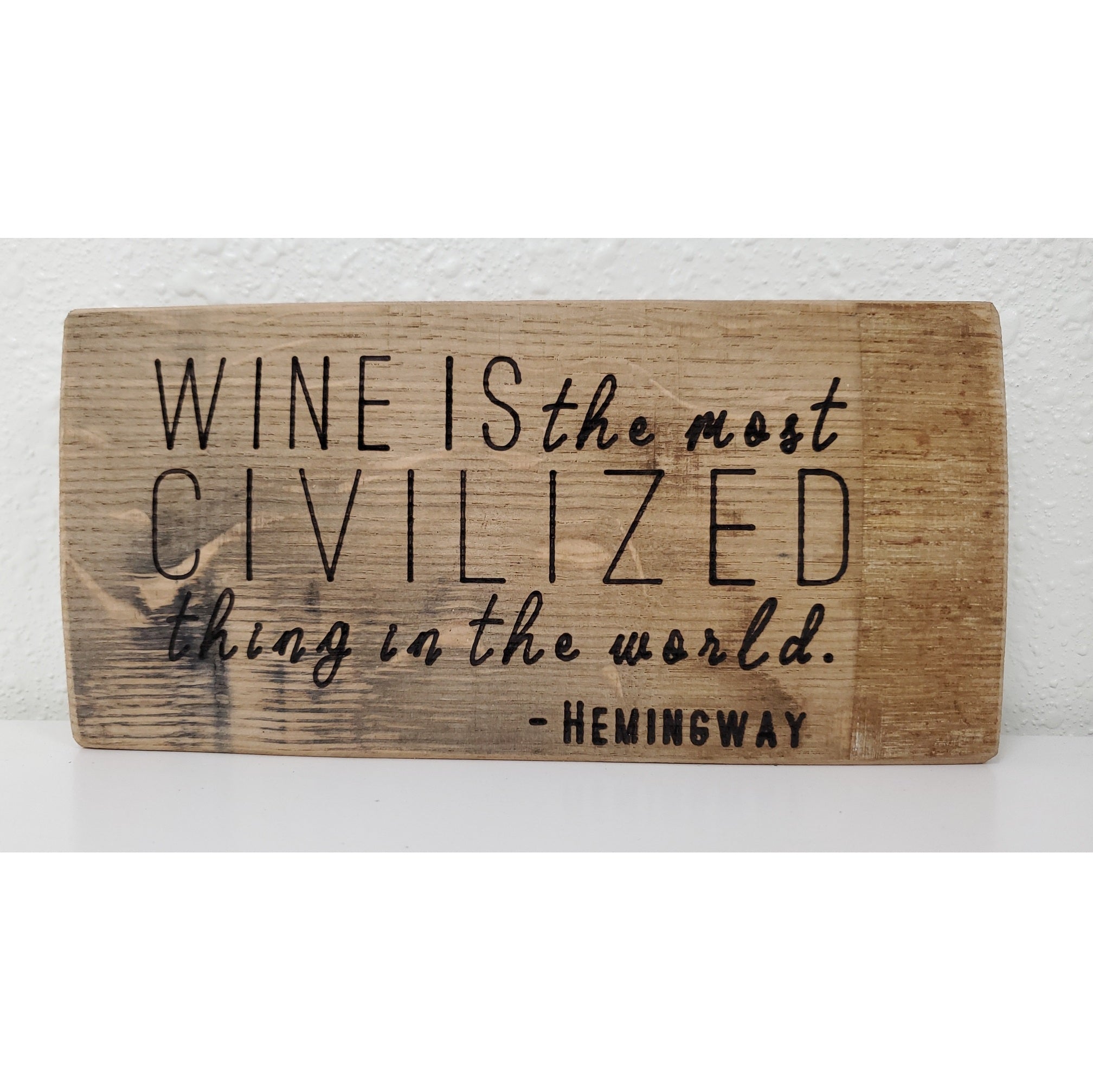 Wooden sign with Hemingway quote on a white background