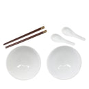 A white ceramic dinnerware set including two bowls, two spoons, and a pair of dark brown chopsticks with gold-colored tips, arranged on a plain white background.