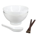 A set of white ceramic diningware including two stacked bowls, two white spoons, and a pair of dark brown chopsticks with gold-toned tips, shown on a plain white background.