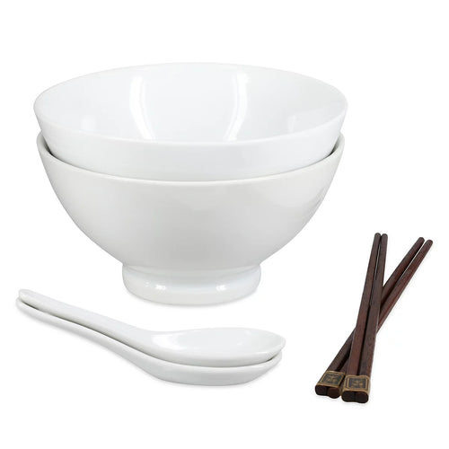 A set of white ceramic diningware including two stacked bowls, two white spoons, and a pair of dark brown chopsticks with gold-toned tips, shown on a plain white background.
