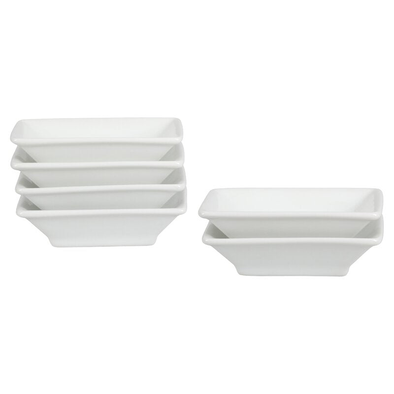A set of white porcelain soy sauce dishes stacked together.