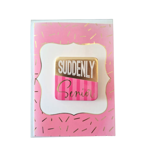 Pink card with gold and a pin that says 'Suddenly Senior' on a white background