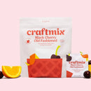 Craftmix Black Cherry Old Fashioned drink mix packages on a pink background