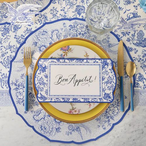 Elegant table setting with floral patterns and 'Bon Appetit' place card.