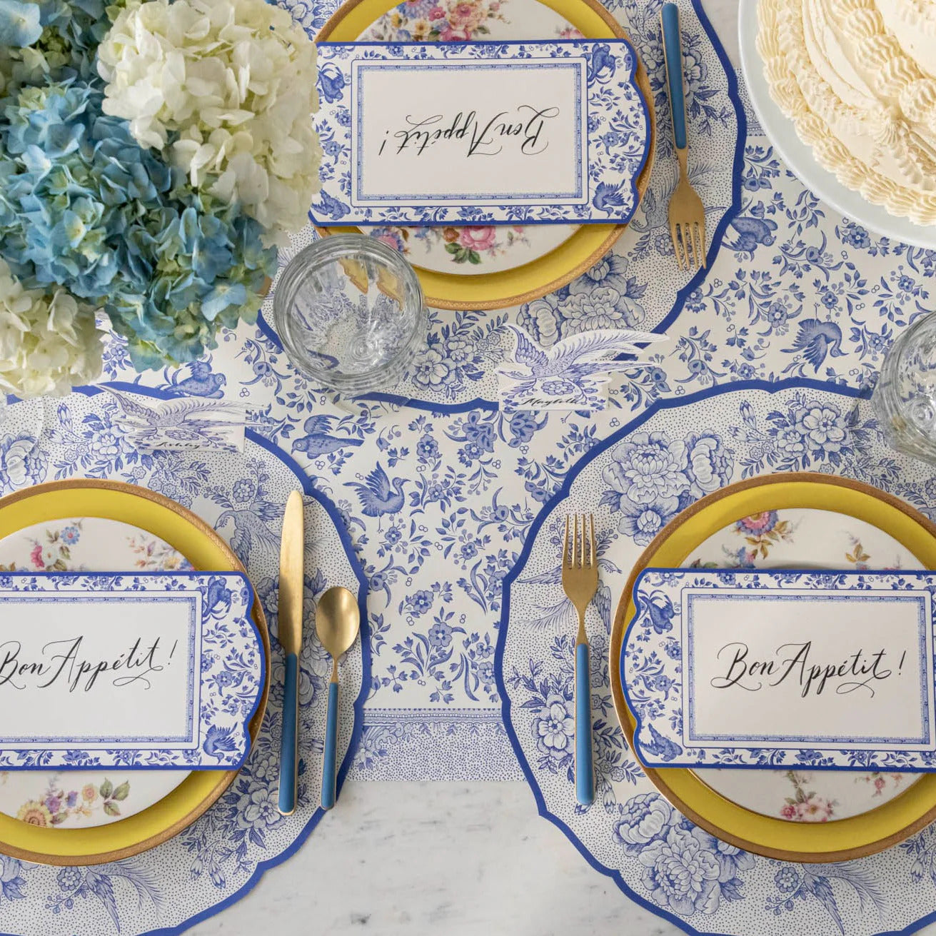 Elegant table setting with floral plates and place cards.