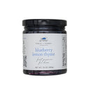 A jar of Blueberry Lemon Thyme jam on a white background.