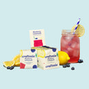 craftmix Blueberry Lemonade packets with a glass of lemonade on a light blue background