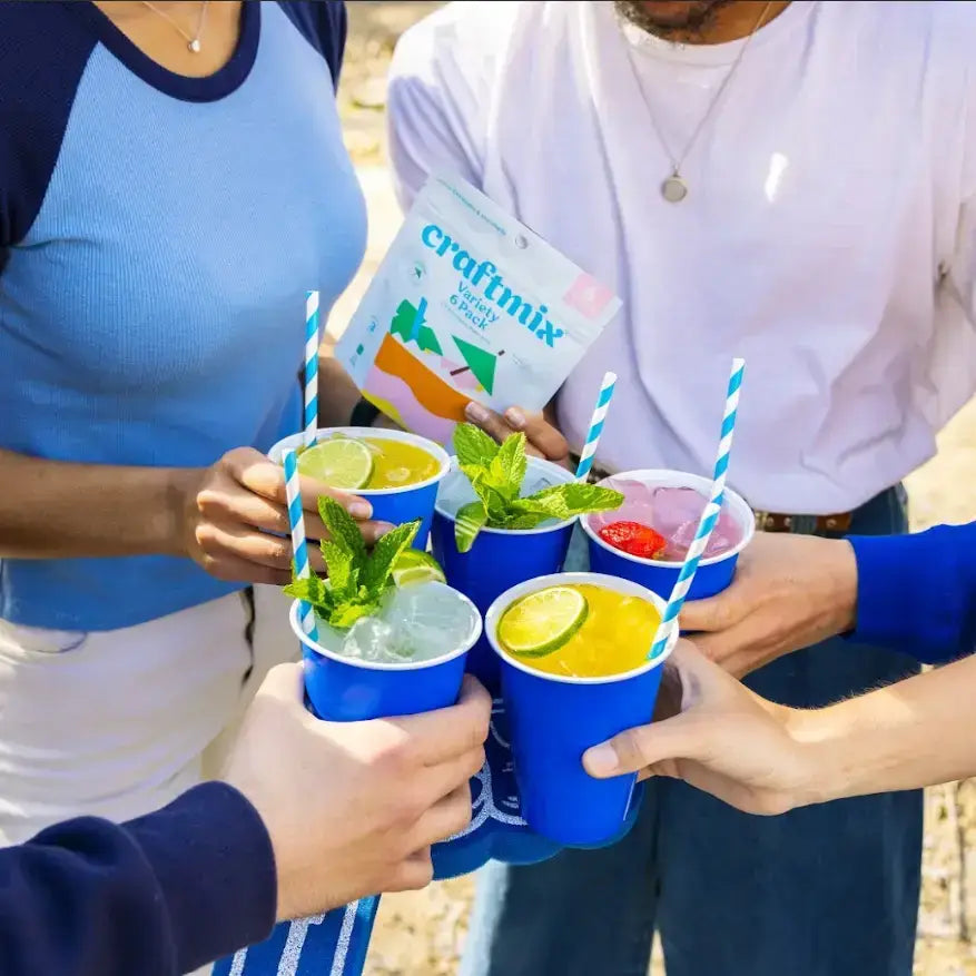 People holding blue cups with drinks and straws, with a 'craftmix' product in the background.
