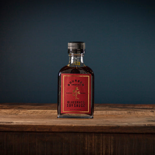 Bottle of Bluegrass Soy Sauce on a wooden surface with a dark background