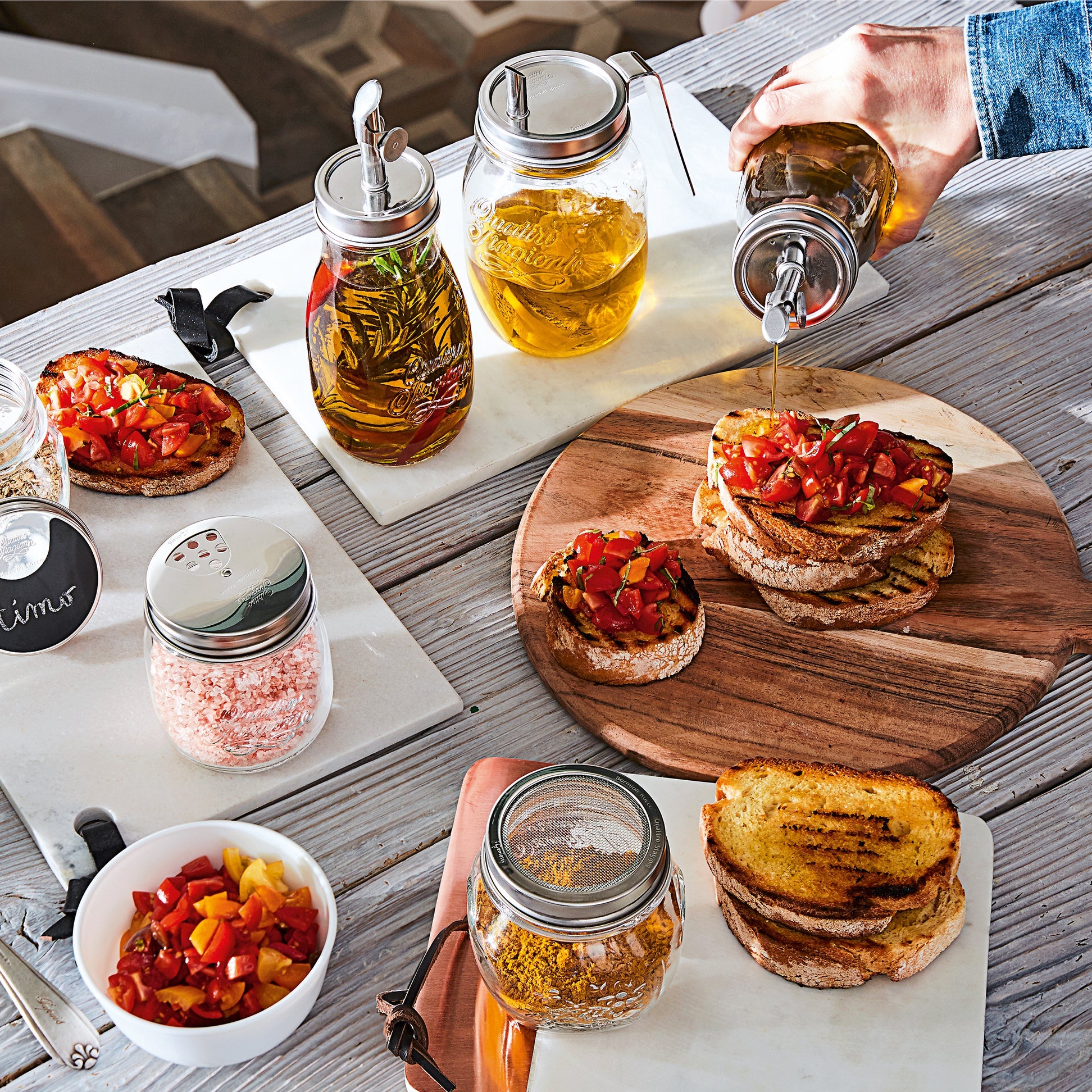 Person preparing a dish with jars of condiments on a wooden table