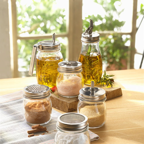 Set of glass jars with metal lids on a wooden surface with a blurred natural background