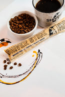 Shiver Stick with coffee beans and a cup of coffee on a white surface