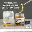 A jar of Collins' Lemon Twist candied lemon peels with a piece of lemon peel dangling from a glass, indicating the product's use in enhancing cocktails.
