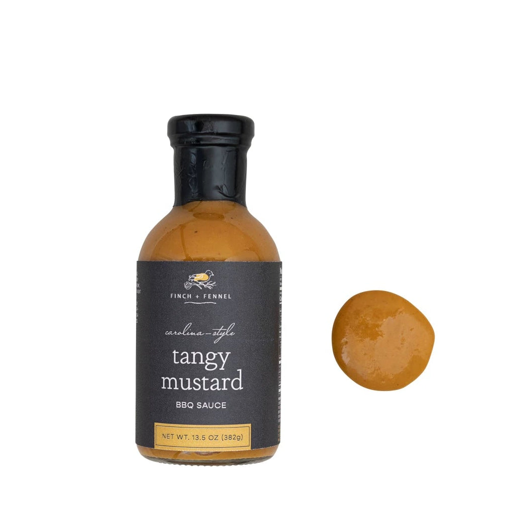 Bottle of tangy mustard BBQ sauce with a sample on a white background