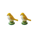 Two ceramic bird salt and pepper shakers on green bases against a white background