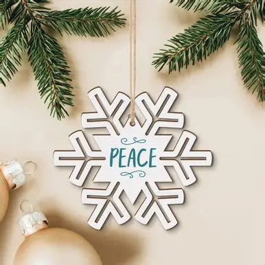 Decorative snowflake ornament with 'PEACE' text, surrounded by Christmas decorations on a beige background.