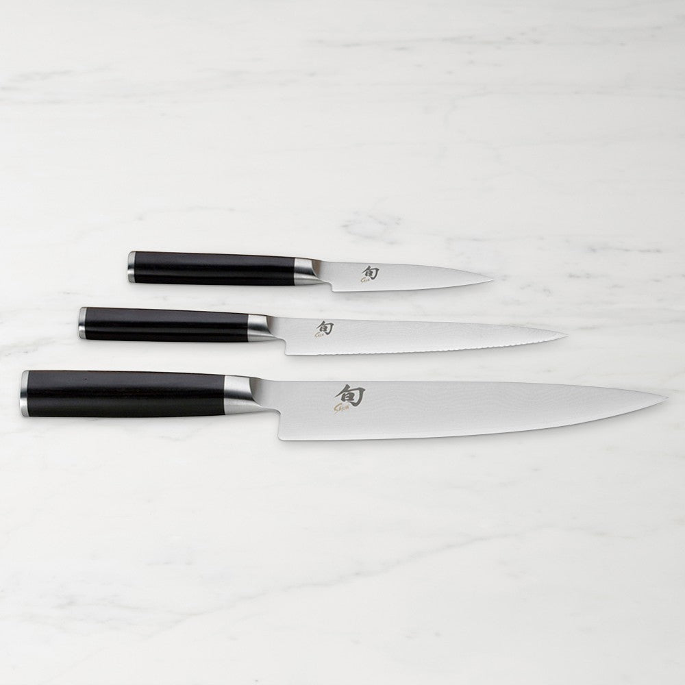 Set of three knives with black handles on a white background