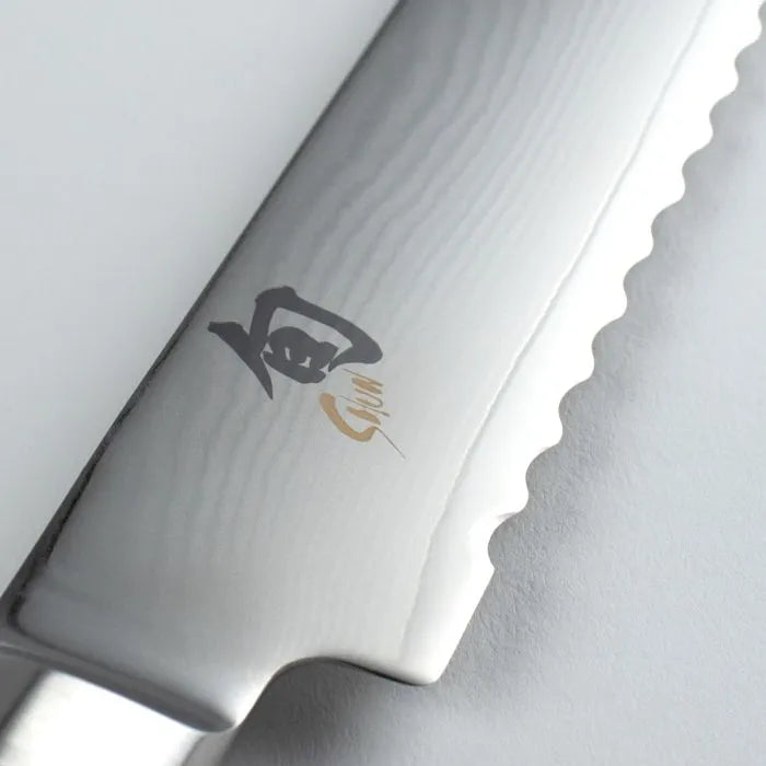 Close-up of a chef's knife with a brand logo on a white background
