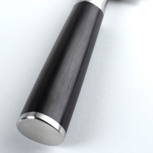 Close-up of a knife handle with metallic bottom on a light gray background