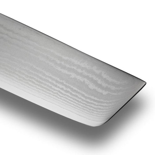 Close-up of a knife edge with a textured surface on a white background
