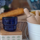 Decorative items including a ceramic blue glass, and wooden rolling pins on a table.