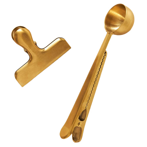 Gold-colored measuring spoon and clamp on a white background